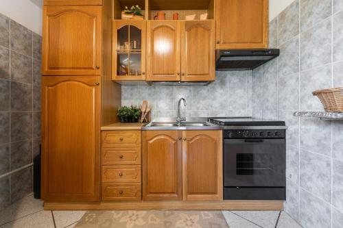 a kitchen with wooden cabinets and a sink at Villa Lidia vicino al mare in Solanas