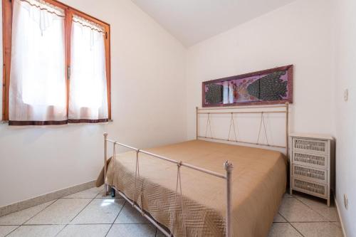 a bedroom with a bed and a window at Villa Lidia vicino al mare in Solanas
