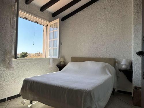 - une chambre avec un lit blanc dans une pièce dotée d'une fenêtre dans l'établissement SP460-047 Mais 5 pièces 8 couchages SAINT PIERRE LA MER, à Saint Pierre La Mer