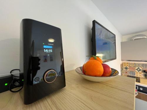 un bol de fruits et un bol d'oranges sur une table dans l'établissement Petite cour privée - à 1minute à pied de la plage, à Merville-Franceville-Plage