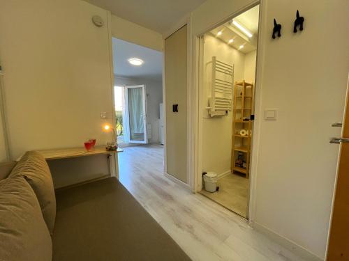 un salon avec un canapé et un miroir dans l'établissement Petite cour privée - à 1minute à pied de la plage, à Merville-Franceville-Plage