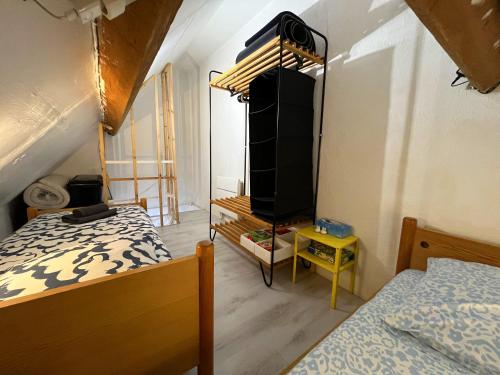 - une chambre avec 2 lits et une commode dans l'établissement Petite cour privée - à 1minute à pied de la plage, à Merville-Franceville-Plage