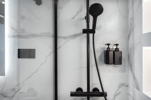 a shower in a bathroom with white marble at Perla Negra - Apartment with Private Beach Access in Benalmádena