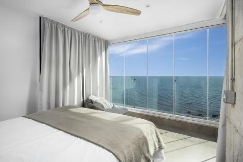 a bedroom with a bed and a large window at Perla Negra - Apartment with Private Beach Access in Benalmádena