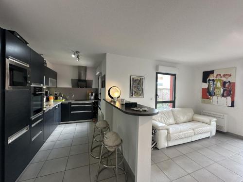 une cuisine et un salon avec un canapé et une table dans l'établissement Superbe 4 pièces climatisé avec terrasse, parking et piscine à 50m de la plage - Sète - FR-1-472-194, à Sète