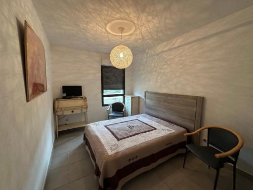 une chambre avec un lit, un bureau et une lampe dans l'établissement Superbe 4 pièces climatisé avec terrasse, parking et piscine à 50m de la plage - Sète - FR-1-472-194, à Sète