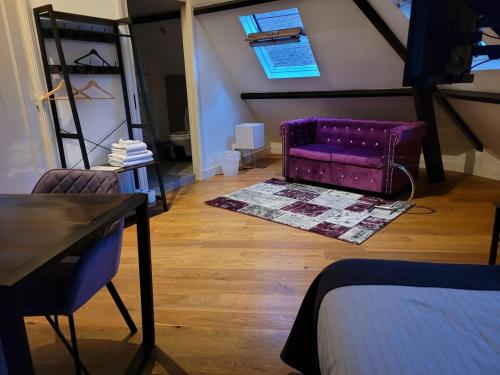 a living room with a purple couch and a table at Stadslogement Bij de Sassenpoort in Zwolle