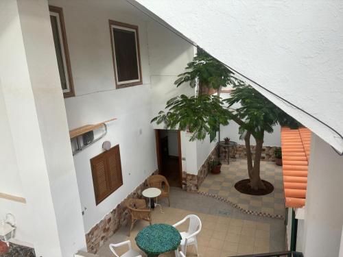 einen Innenhof mit einem Tisch, Stühlen und einem Baum in der Unterkunft Sweet Life in Costa Del Silencio