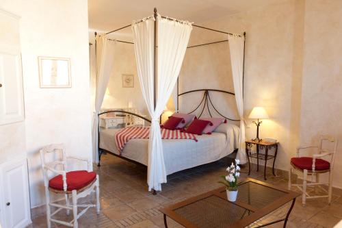 a bedroom with a canopy bed with red pillows at Omma in Roussillon