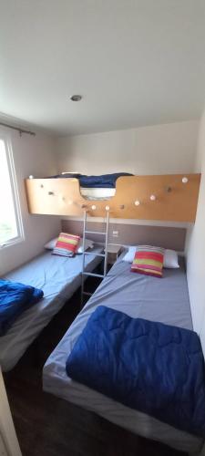 Ce lit se trouve dans un dortoir doté de lits superposés. dans l'établissement Mobil home 5 personnes vue mer, à Tihen