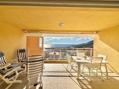une salle à manger avec une table et des chaises sur un balcon dans l'établissement Appartement Le Diana Sanguinaires Ajaccio, à Ajaccio