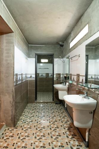 a bathroom with two sinks and a shower and two mirrors at Hmong Farmstay in Sa Pa