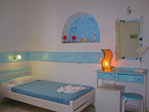 - une chambre avec un lit, un bureau et un miroir dans l'établissement Kymata, à Mykonos