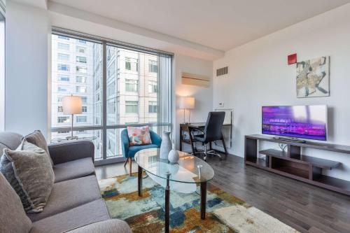 a living room with a couch and a tv at Luxury Apt Near Kendall Sq in Cambridge