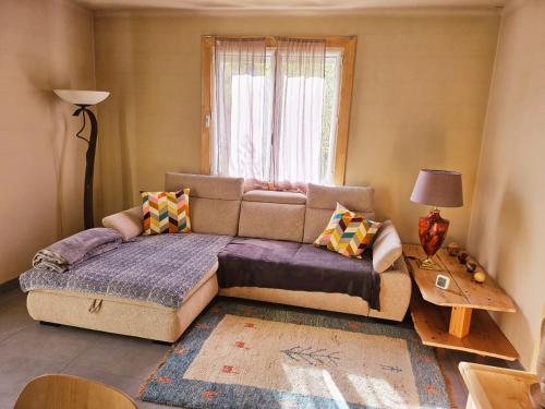 a living room with a couch and a window at Maison au bord de l'eau in Le Thor