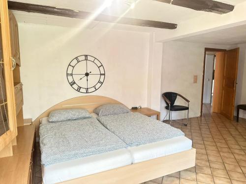 a bedroom with a bed and a clock on the wall at Haus mit Terrasse&Garten in Ilsede