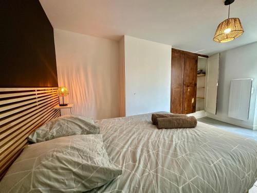 Un dormitorio con una cama grande con una almohada. en Nid douillet pour 2 au Puy, en Le Puy en Velay
