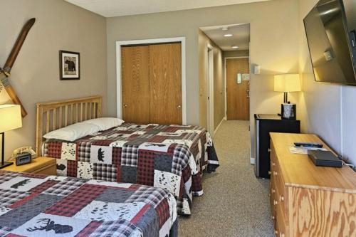 ein Hotelzimmer mit zwei Betten und einem Schreibtisch in der Unterkunft Riverview Efficiency at Rivergreen in Lincoln