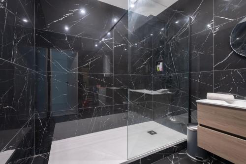 La salle de bains noire est pourvue d'une douche et d'un lavabo. dans l'établissement Bel appart St Fé, Moderne et Central pour 2 personnes, à Marseille