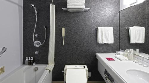 a bathroom with a shower and a toilet and a sink at ANA Crowne Plaza Niigata by IHG in Niigata