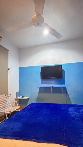 a bedroom with a bed with a blue wall at Santorini House in Bali Near Airport in Kuta