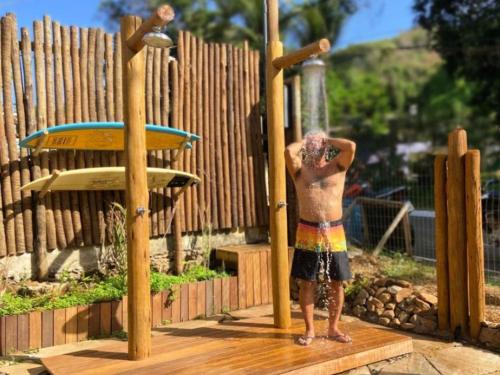 a shirtless man standing next to a water fountain at Vila Cris in Fernando de Noronha