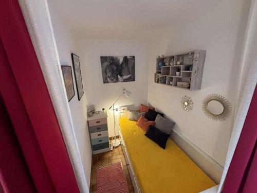 Cette petite chambre dispose d'un couloir avec un sol jaune. dans l'établissement Appartement Lumineux à 300m Plage, Balcon et Parking - 3 Couchages - FR-1-229C-22, à Port-la-Nouvelle