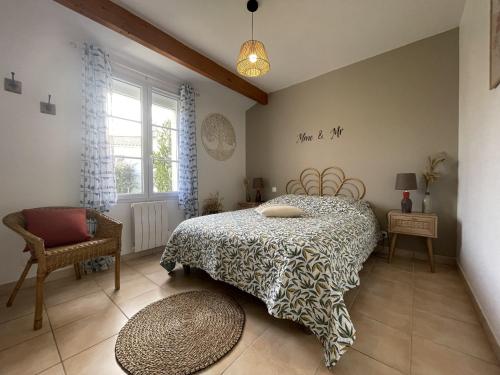 une chambre avec un lit, une chaise et une fenêtre dans l'établissement Les Alizes, à Givrand