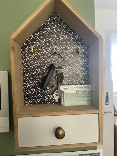 une armoire en bois avec un téléphone et un livre dans l'établissement Les Alizes, à Givrand