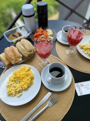a table with plates of breakfast food and a cup of coffee at Varandas do Vale Chalé in Monte das Gameleiras