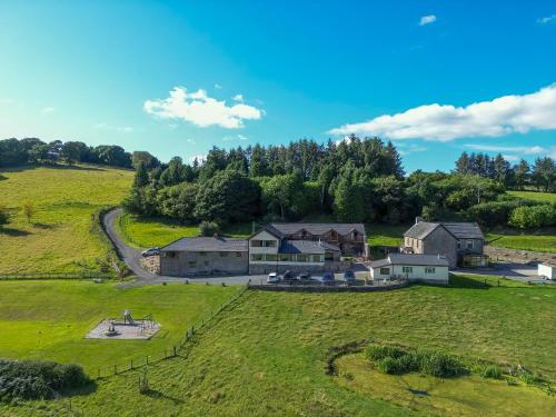 an aerial view of a house on a green field at Vale Farm Cottages in Brecon