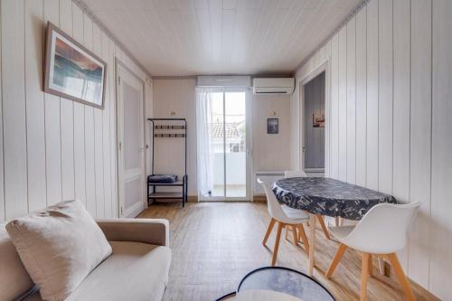 un salon avec une table et un canapé dans l'établissement Appartement St Arnaud, à Arcachon