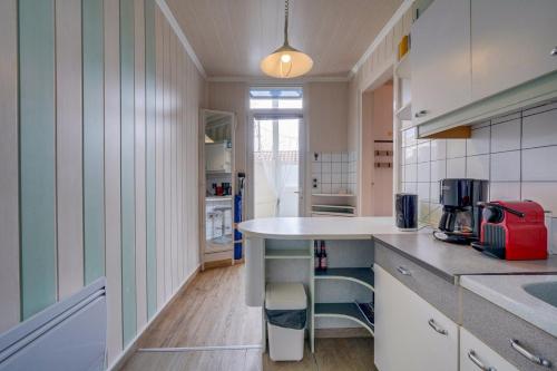 une cuisine avec des placards blancs et un comptoir dans l'établissement Appartement St Arnaud, à Arcachon