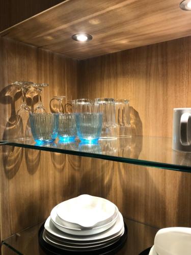 une étagère en verre avec des assiettes et des verres dessus dans l'établissement your studio in Collioure, à Collioure