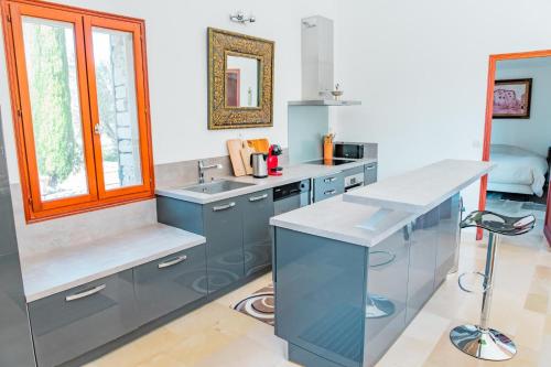 une cuisine avec des armoires bleues et un évier dans l'établissement Maison de charme avec piscine à Gordes, à Gordes
