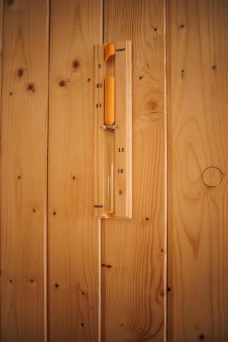 a light on a wooden wall with a thermometer at Daheim in Râşnov