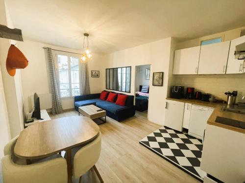 un salon avec un canapé bleu et une cuisine dans l'établissement Appartement sur cour quartier Olympiades, à Paris