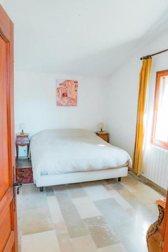 une chambre avec un lit blanc et une fenêtre dans l'établissement Maison de charme avec piscine à Gordes, à Gordes