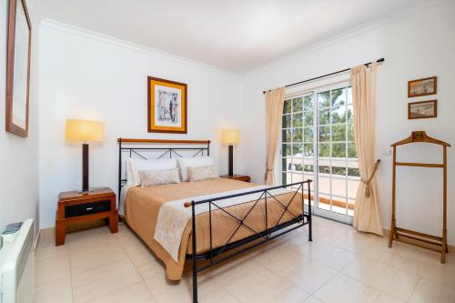a bedroom with a bed and a large window at Villa Audiência 145 in Castro Marim