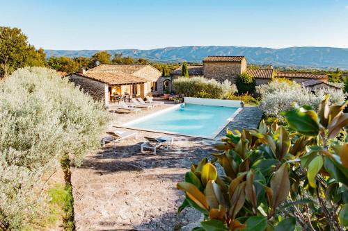 une maison avec une piscine dans une cour dans l'établissement Maison de charme avec piscine à Gordes, à Gordes
