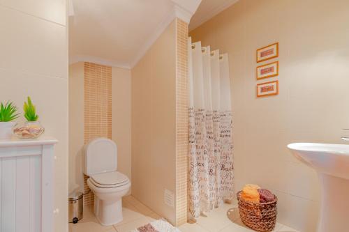 a bathroom with a toilet and a sink at Villa Audiência 145 in Castro Marim