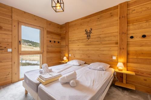 - une chambre avec des murs en bois et un lit avec des serviettes dans l'établissement La Jolie Etoile - Proche pistes et vue montagnes, aux Angles