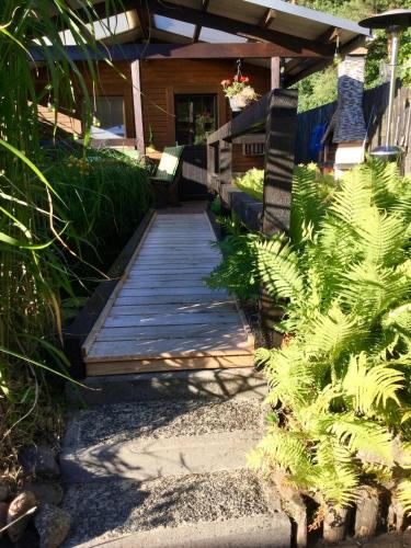 a wooden walkway leading to a house with plants at Ferienhaus Walddomizil in Neustadt-Glewe