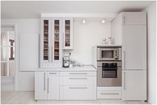a white kitchen with white cabinets and appliances at Chalupa Purpurová lúka Velké Karlovice in Velké Karlovice