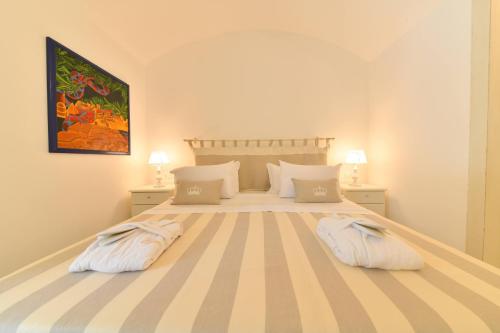 a bedroom with a large bed with two pillows at Queen Suite - Luxury Rooms in Ischia