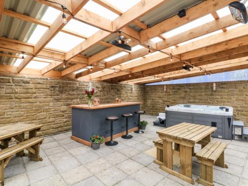 un patio con bancos y bañera de hidromasaje. en Poacher's Arms, en Hope