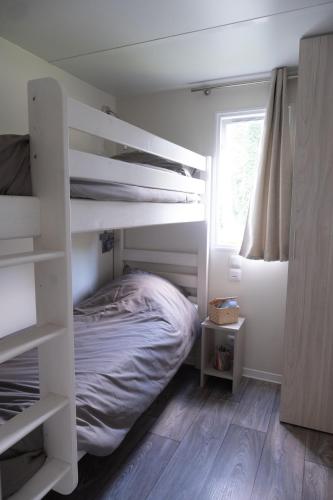 - une chambre avec des lits superposés blancs et une fenêtre dans l'établissement Mobil Home XXL 4 chambres - Camping Country Park, à Touquin