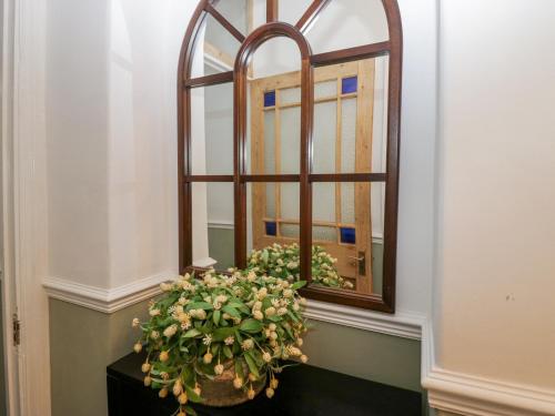 a plant sitting on a table in front of a mirror at Willow Cottage in Carnforth