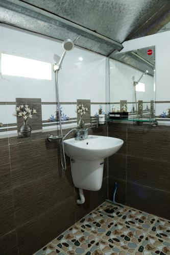 a bathroom with a white sink and a shower at Hmong Farmstay in Sa Pa