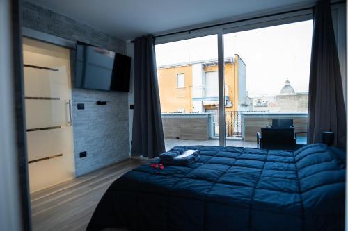a bedroom with a bed and a large window at casa con veranda e idromassaggio in Barletta